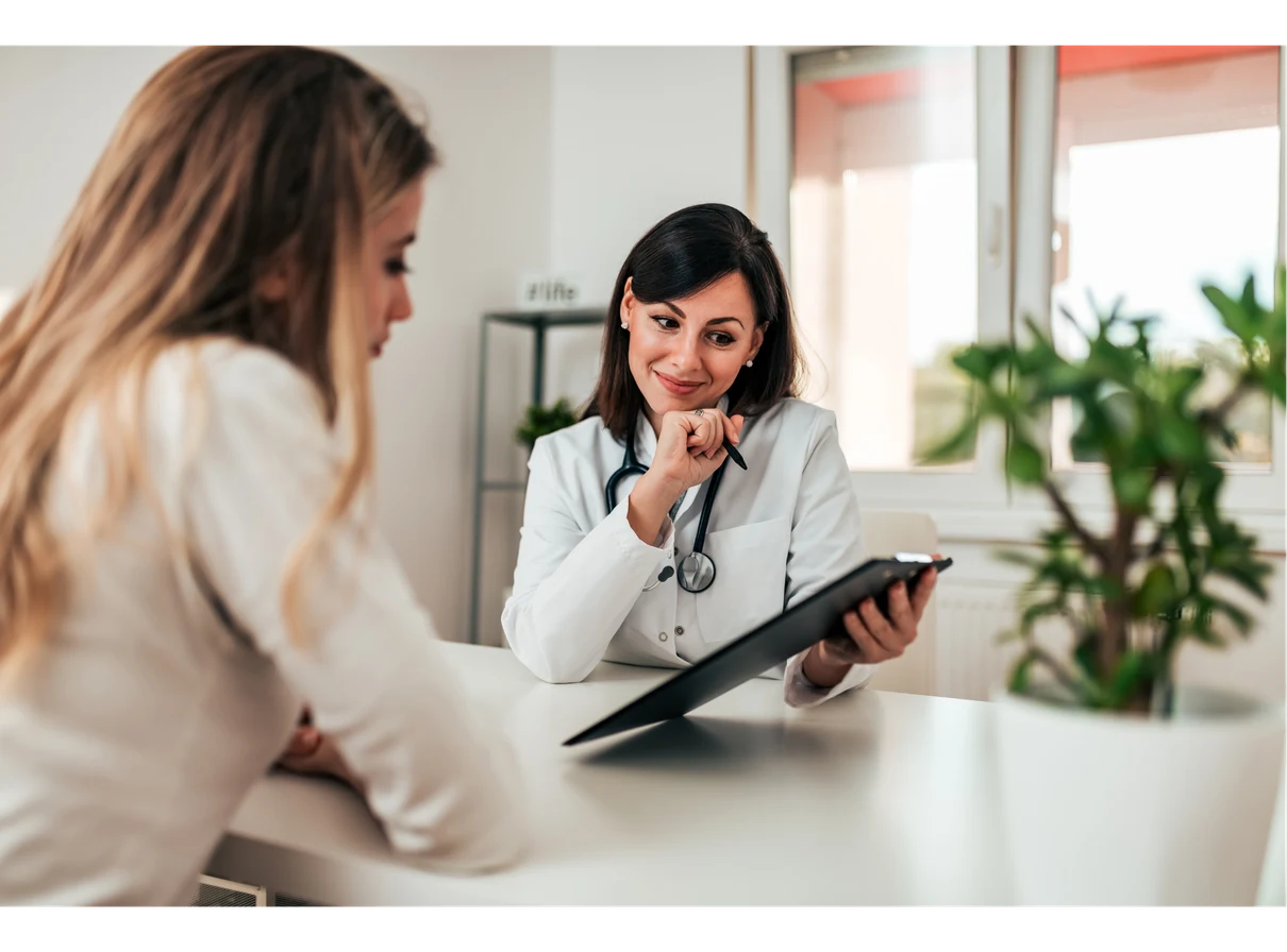Doctor speaking with a female patient during a consultation in a private clinic.