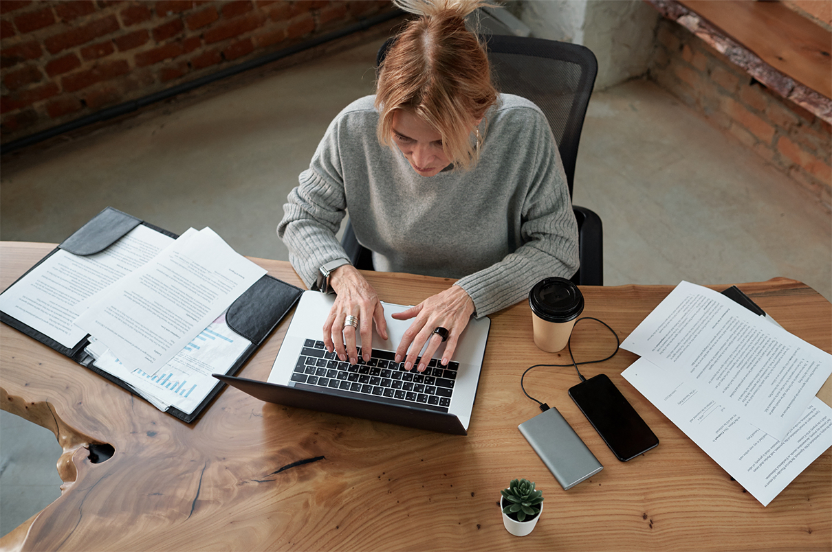 Legal professional reviewing and organizing documents on a laptop